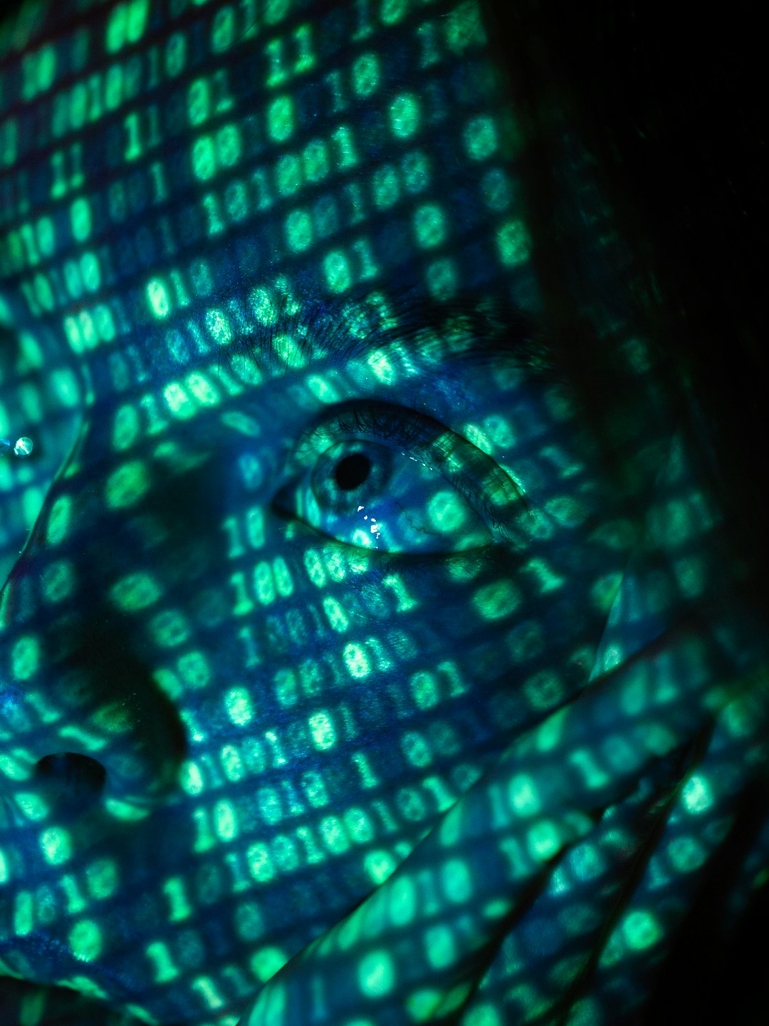 Digitale binaire code geprojecteerd op iemands gezicht.